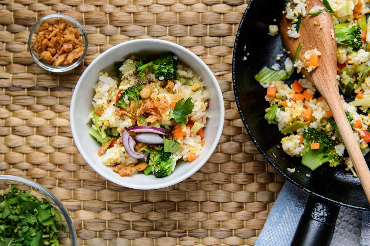 A bowl of colorful fried rice garnished with green onions