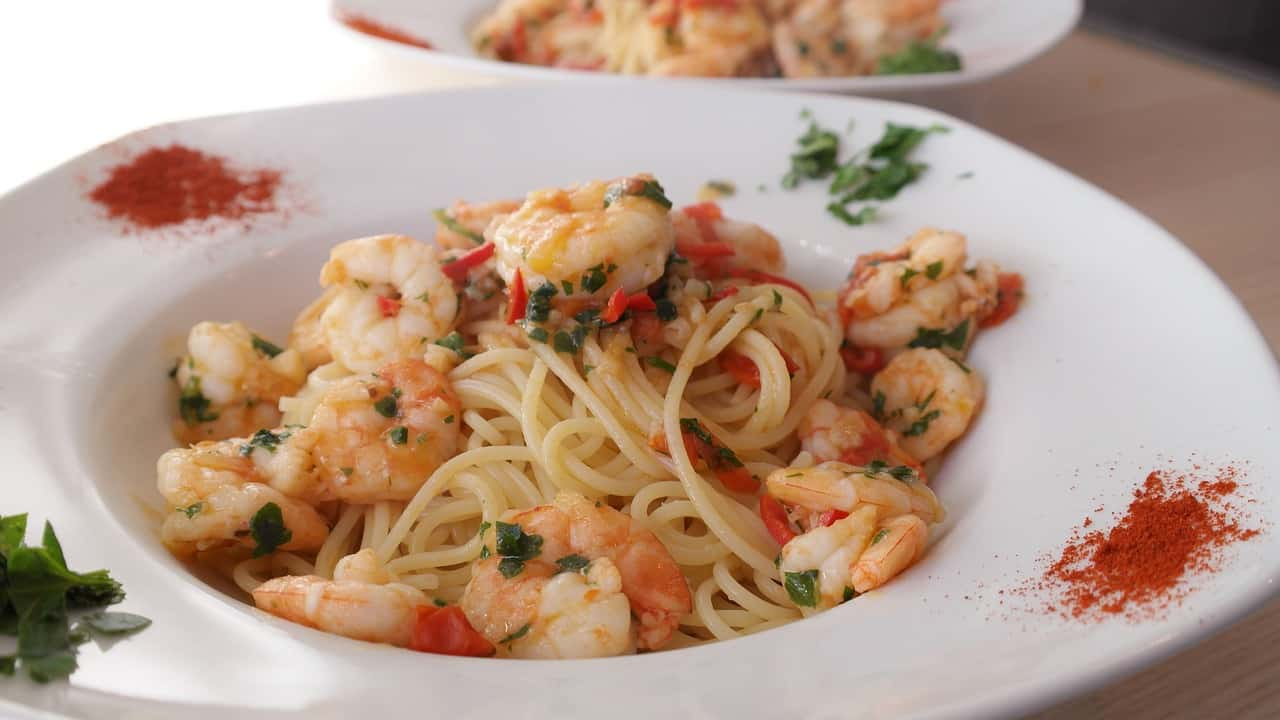 A plate of garlic butter shrimp pasta garnished with fresh parsley