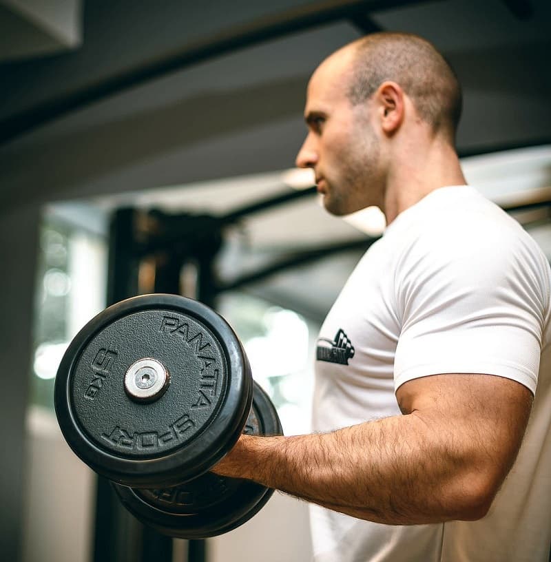 A person performing a squat or lifting a dumbbell, representing strength training