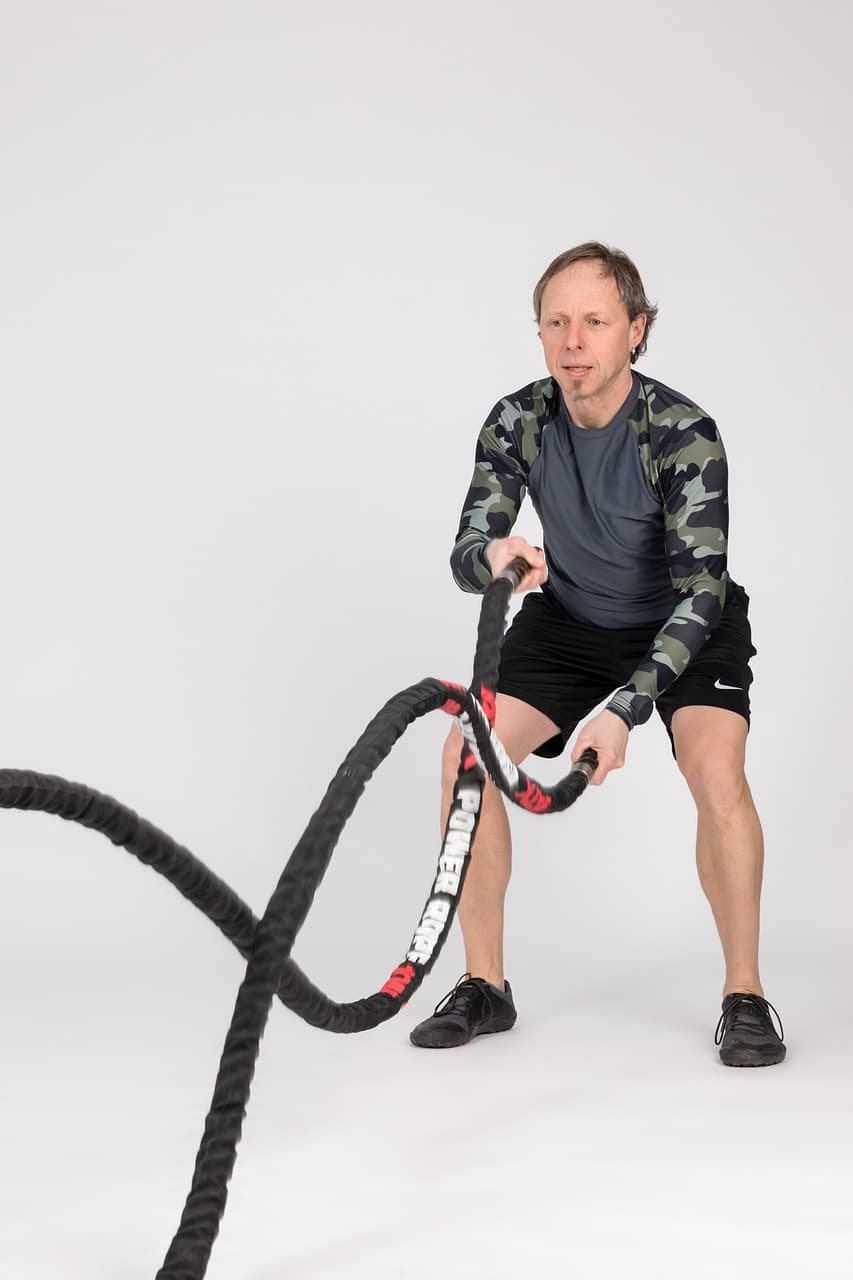 A dynamic image of someone using battle ropes with strong, powerful movements.